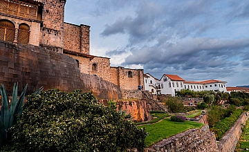 Cusco muro inca y arquitectura colonial, vista panorámica con jardines y cielo nublado